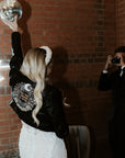 Custom black leather bride jacket with celestial motifs, including moon and stars embroidery, creating a one-of-a-kind wedding cover-up for the modern bride
