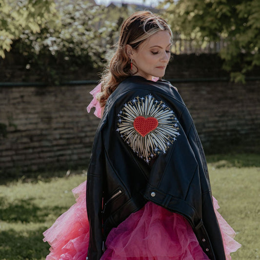 Bold red heart-shaped leather jacket for brides, a stunning and custom bridal cover-up featuring zodiac embroidery – a perfect choice for a unique Valentine's-themed wedding look