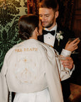 Bridal cover-up in ivory with Zodiac embroidery and Pinky Promise from Skeleton Couple – a unique and custom leather jacket for brides looking to add a personal touch to their ensemble
