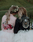 Edgy and personalized bridal cover-up – a cropped black leather jacket with zodiac embroidery, perfect for brides who want a unique and trendy wedding ensembl