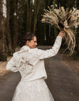 Celestial-Inspired Ivory Wedding Jacket: Elevate your bridal attire with this ethereal cover-up, adorned with celestial details and delicate ecru embroidery