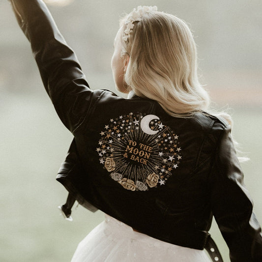 Chic black cropped leather jacket with celestial-inspired moon and stars embroidery, perfect as a custom bridal cover-up for a unique wedding look
