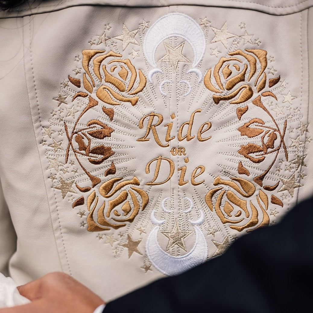 Bride&#39;s ivory leather jacket featuring zodiac embroidery – a custom and chic cover-up, making it an ideal gift from bridesmaids for the ride-or-die bride