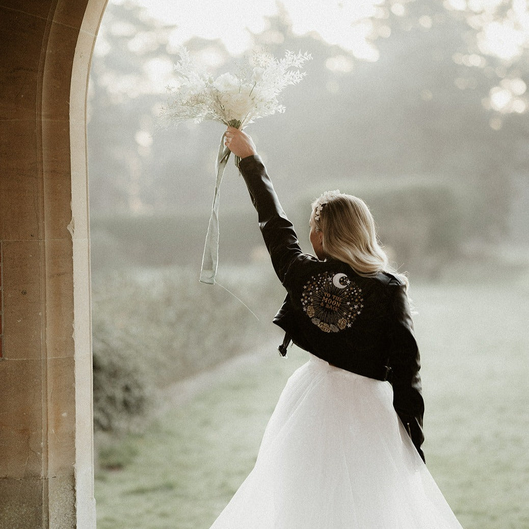 Bride's custom leather jacket featuring intricate zodiac embroidery, a stylish and edgy choice for a celestial-themed wedding ensemble